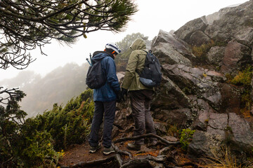 Adventurous hikers exploring rocky trail on a misty day