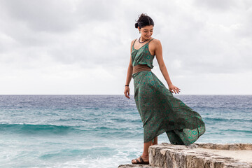 Young woman in green dress by the Caribbean Sea
