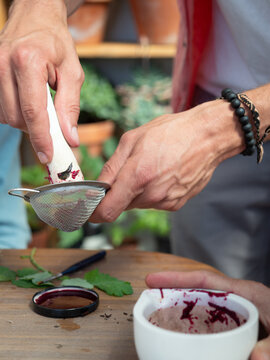 Artisan filtering beetroot juice for natural ink or pigment creation