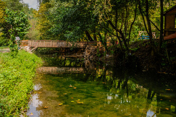Tranquil Creek with Wooden Footbridge Surrounded by Lush Greenery in Başiskele, Kocaeli, T&uuml;rkiye on a Sunny Day