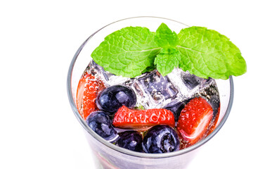 Fruit soda with berries, ice and mint in a glass on white background. Fresh summer drink, top view.