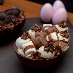 Chocolate easter eggs on top of black stone with wooden background