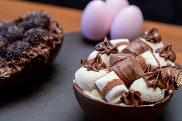 Chocolate easter eggs on top of black stone with wooden background