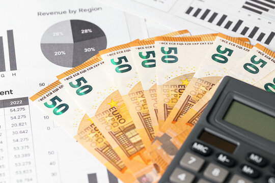 Fifty euro banknotes with calculator. Financial planning and eurozone budget concept. Business report and statistics. Money saving strategy. Economic analysis with currency and data charts.