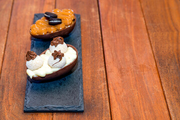 Chocolate easter eggs on top of black stone with wooden background