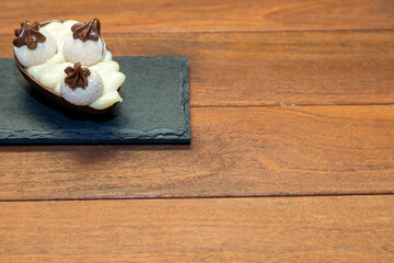 Chocolate easter eggs on top of black stone with wooden background