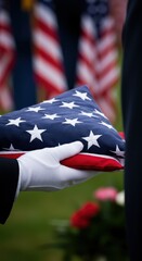 A folded American flag, held with respect, stands as a poignant symbol of remembrance and sacrifice during a solemn ceremony.
