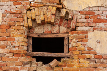 Broken window in old red brick wall
