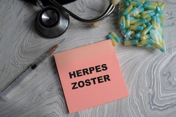 Concept of Herpes zoster write on sticky notes isolated on Wooden Table. stethoscope and pharmaceuticals