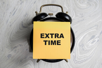 Concept of Extra time write on sticky notes isolated on Wooden Table.