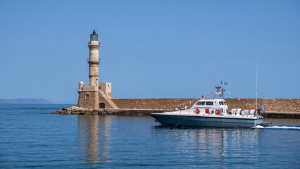 Chania Crete. A boat and lighthouse at old venetian port, blue sky