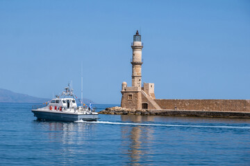 Chania Crete. A boat and lighthouse at old venetian port, blue sky