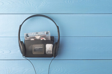 Retro cassette player with classic headphones on blue wooden boards brings a nostalgic vibe of the...