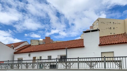 Rooftops basking under whimsical skies, evoking sun-dappled siestas and Spanish siesta retreats on...