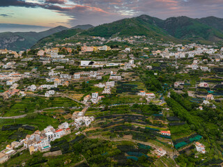 Aerial view of Ravello, Italy, featuring hillside terraces, white villas, lush greenery, and a...