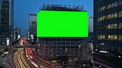 Fixed elevated shot of neon-green billboard above urban highway, glowing green screen stop mid-rise building framed by scaffolding and high-rise glass towers, perfect for city branding or digital ads. - Powered by Adobe
