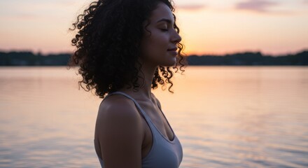 Serene woman meditating at dusk by the tranquil lake, capturing inner peace