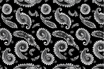 A detailed black and white paisley pattern with swirling shapes and floral elements scattered throughout it