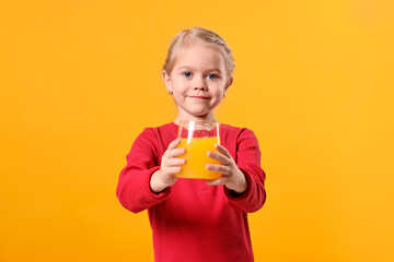 Girl with glass of juice on orange background. Refreshing drink