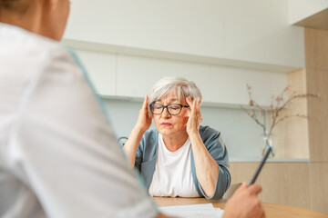 Female doctor examining older senior woman in doctor office or at home. Old woman lady patient and...