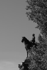 Majestic warrior statue on horseback overlooks Japan's serene landscape under a clear afternoon sky