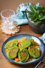 Green pea cakes on mashed carrot and parsnip. Vegetable fritters, pancakes on blue plate