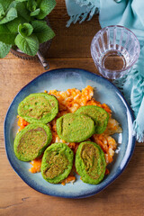 Green pea cakes on mashed carrot and parsnip. Vegetable fritters, pancakes. View from above, top studio shot