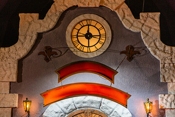Christmas clock tower with curved entrance, stylized fish motif, circular window or light,...