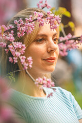 Naklejka premium beautiful blonde girl and pink tree blossom 