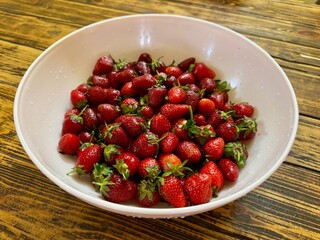 Fresh Strawberries in White Bowl on Rustic Wooden Table