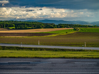 South Bohemian countryside near Česk&eacute; Budějovice, Czech Republic &mdash; a scenic farmland landscape with roads, fields, and distant hills under dramatic evening clouds