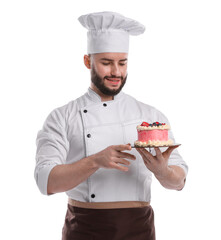 Happy confectioner in uniform holding delicious cake with berries on white background