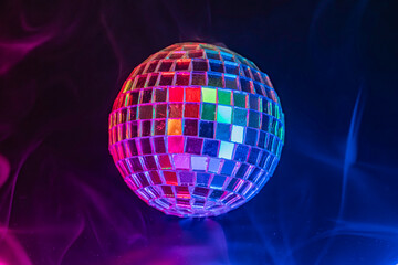 Obraz premium Disco ball floating in a dark, smoke-filled background with vibrant lights Commonly associated with party scenes, events like parties, concerts, nightclubs, or music and entertainment
