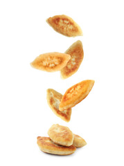 Tasty baked patties falling on white background