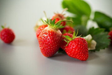 Fresh strawberries of juicy red color on a minimalistic background