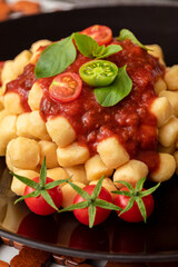 Close up on traditional italian potato gnocchi in tomato sauce with fresh basil and Cherry tomato