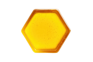 Hexagonal honeycomb slice on white background with golden liquid, cut out