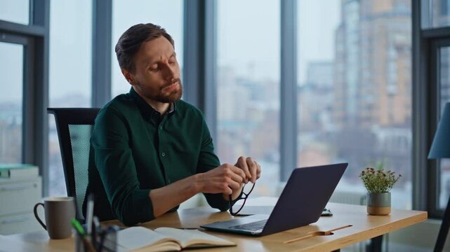 Pensive worker thinking issues looking laptop in office closeup. Serious man