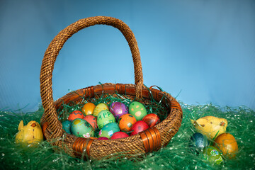 Easter basket full of eggs sitting in green plastic grass