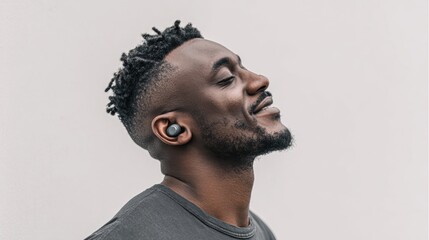 Obraz premium Man enjoys music with wireless earbuds, showcasing relaxation and modern technology.