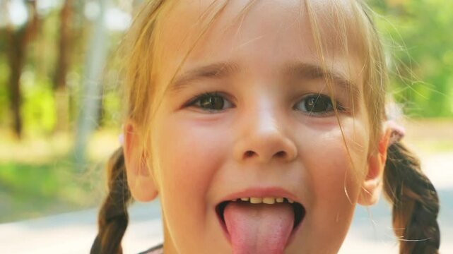 Close up of a preschool girl face grimacing outdoor
