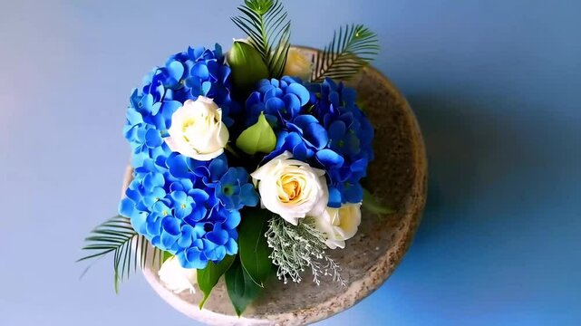 White roses and blue hydrangeas in a pot
