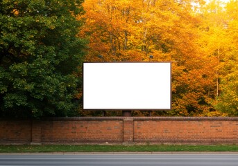 Empty Ad Hoarding on a Roadside Brick Wall, Framed by Green and Golden Autumn Trees