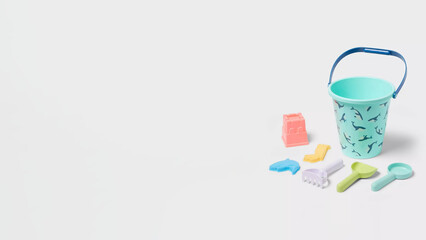 Plastic beach toys arranged on a light surface ready for fun in the sun at a seaside location during summer season.