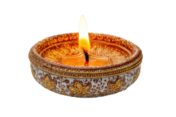 Decorative clay diya with intricate patterns and flame on black background, cut out