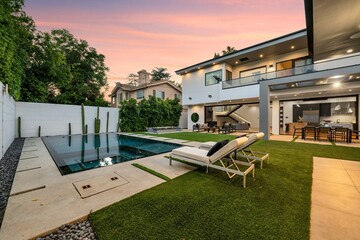 Modern luxury home exterior at sunset with pool, outdoor lounge, and contemporary architecture