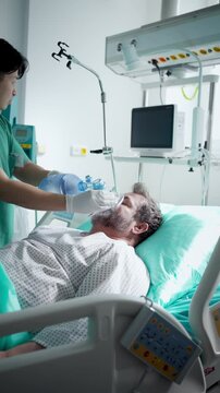 Doctor providing oxygen ventilation to unconscious patient in hospital.
