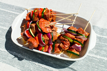Raw beef Kebabs in a white bowl 
