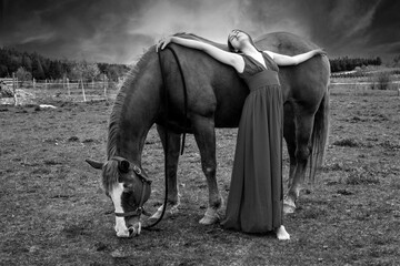 A young woman in a black and white picture with a horse