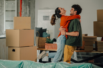 Happy couple embracing in new home after moving in, celebrating new beginning
